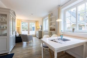 a living room with a white table and chairs at Feriendomizil App 7 in Wenningstedt