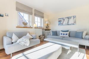 a living room with two couches and a table at Feriendomizil App 3 in Wenningstedt