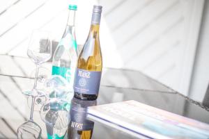 duas garrafas de vinho sentadas numa mesa com copos em Haus Sonnenschein Whg H em Wenningstedt