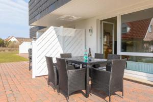 eine Terrasse mit einem Tisch und Stühlen auf einem Haus in der Unterkunft Haus Sonnenschein, Whg. H in Wenningstedt-Braderup