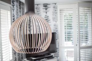 a large vase hanging from the ceiling in front of a television at SYLThouse in Wenningstedt