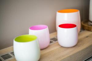 three different colored vases sitting on a wooden shelf at SYLThouse in Wenningstedt