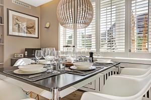 a dining room table with white chairs and a chandelier at SYLThouse in Wenningstedt