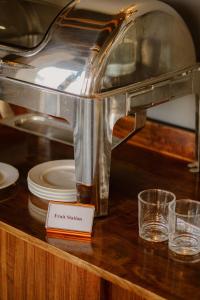 a coffee machine on a counter with plates and glasses at SERENE Stays Hotel in Yangon