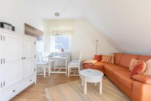uma sala de estar com um sofá e uma mesa em Haus Sonnenschein Whg G em Wenningstedt