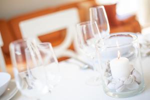 a candle in a vase on a table with glasses at Haus Sonnenschein Whg G in Wenningstedt +18 photos