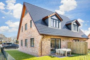 a brick house with a gambrel roof at Nordlicht in Tinnum