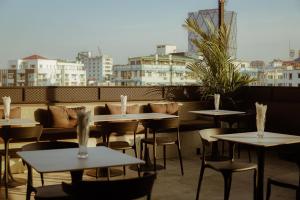 a restaurant with tables and chairs on a roof at SERENE Stays Hotel in Yangon