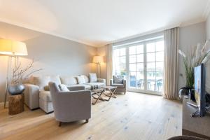 ein Wohnzimmer mit Couch und Fernseher in der Unterkunft Düün Hüs, App. 2 in Westerland