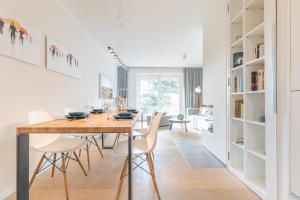 a dining room and living room with a table and chairs at Ameland App 4 in Wenningstedt