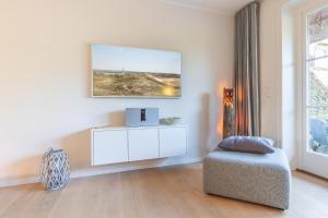 a living room with a white cabinet and a window at Ameland App 4 in Wenningstedt