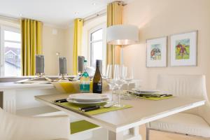 - une salle à manger blanche avec une table et des chaises blanches dans l'établissement Nette Sun App 10, à Westerland