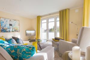 - un salon avec des rideaux jaunes et un canapé dans l'établissement Nette Sun App 10, à Westerland