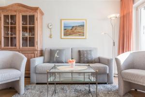 uma sala de estar com dois sofás e uma mesa de centro em Fewo Atlantik App 4 em Wenningstedt