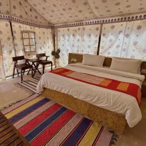 ein Schlafzimmer mit einem Bett und einem Tisch in einem Zimmer in der Unterkunft Night Stay Camp in Jaisalmer