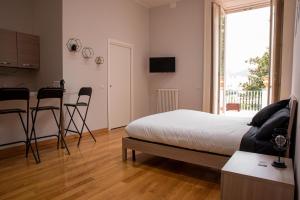 una camera con letto e una cucina con tavolo di Royal Palace B&B a Caserta