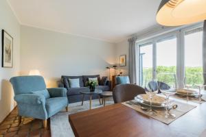 sala de estar con sofá azul y mesa en Passat App 5, en Wenningstedt
