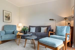 a living room with a couch and two chairs and a table at Passat App 5 in Wenningstedt