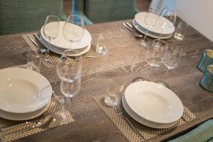 uma mesa com pratos brancos e copos de vinho em Haus Mateika Whg 7 em Westerland