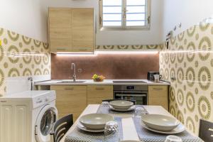 una cucina con tavolo e lavatrice di Pollicita 80 a Chiaramonte Gulfi