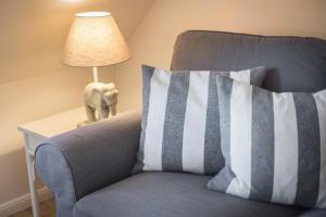 a blue couch with a pillow next to a lamp at Wattwind in Braderup