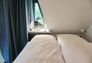 a bed in a room with a window at Landhaus Braderup in Braderup