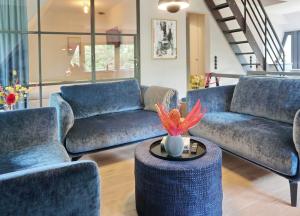 a living room with blue couches and a table at Landhaus Braderup in Braderup