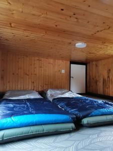 蘭瑙的住宿－The Mountain Camp at Mesilau, Kundasang by PrimaStay，一张位于带木制天花板的客房内的大床