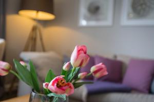 een vaas gevuld met roze bloemen op een tafel bij Watthues Wenningstedt in Wenningstedt