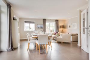 een eetkamer en woonkamer met een tafel en stoelen bij Watthues Wenningstedt in Wenningstedt