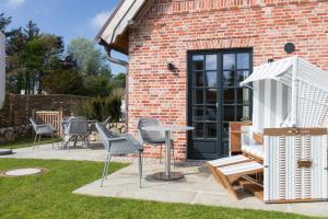 a patio with chairs and a table and an umbrella at Lille Wung in Wenningstedt