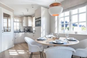 a kitchen and dining room with a table and chairs at Lille Wung in Wenningstedt +24 photos