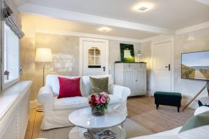 a living room with a white couch and a table at Kampende II in Tinnum