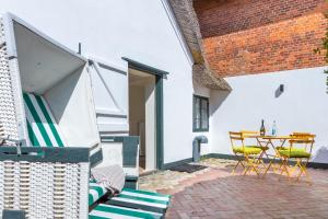 an outdoor patio with a table and chairs at Kampende II in Tinnum