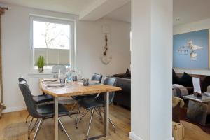 ein Esszimmer und ein Wohnzimmer mit Tisch und Stühlen in der Unterkunft Sylter Stubn  in Westerland