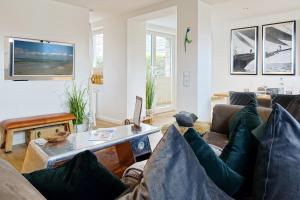 ein Wohnzimmer mit einer Couch und einem Tisch in der Unterkunft Sylter Stubn  in Westerland