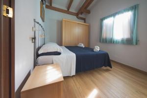 a bedroom with a bed with a blue blanket and a window at Heliopolis Camping & Village in Pineto