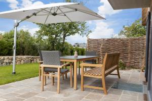 a table and chairs under an umbrella on a patio at Fien to Huus in Wenningstedt
