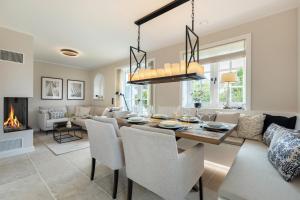 a dining room and living room with a table and chairs at Fien to Huus in Wenningstedt