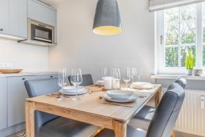 een keuken met een houten tafel met stoelen en wijnglazen bij Kamp 28 in Westerland