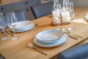 een houten tafel met borden en vorken en wijnglazen bij Kamp 28 in Westerland