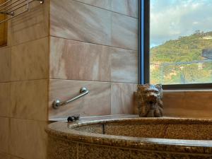 uma casa de banho com uma banheira e uma janela em Grand Pleasure Spring Hotel em Taipei