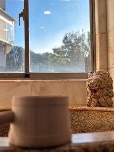 an owl figurine sitting on a window sill next to a cup at Grand Pleasure Spring Hotel in Taipei