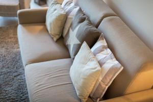- un canapé avec des oreillers dans le salon dans l'établissement Duenen Meer App 2 Duenen Nest, à Westerland