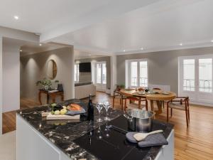 a kitchen and living room with a table and a counter at Burgundy Heritage Collection - Refuge d'Exception au cœur d'Autun in Autun