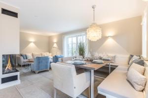 a dining room and living room with a table and chairs at Beachmemories in Wenningstedt