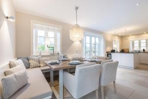a dining room and kitchen with a table and chairs at Beachmemories in Wenningstedt