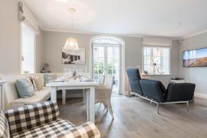 ein Wohnzimmer mit Tisch und Stühlen in der Unterkunft Haus Seaside in Wenningstedt-Braderup