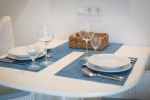 ヴェニングシュテットにあるSyltblume App 11の白いテーブル(皿、ワイングラス付)