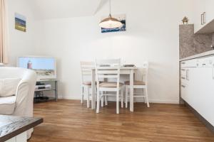 ヴェニングシュテットにあるHaus Heideresidenz App 23のキッチン、ダイニングルーム(白いテーブル、椅子付)